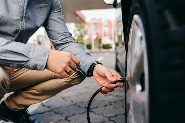 Person Checking Their Car's Tire Pressure | University Chevron in Fairbanks, AK